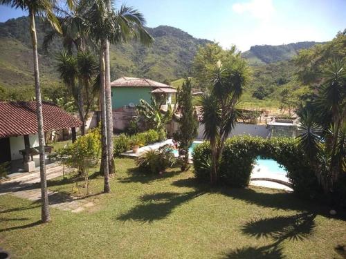 um resort com piscina e palmeiras em Casa com piscina em Aldeia Velha em Quartéis