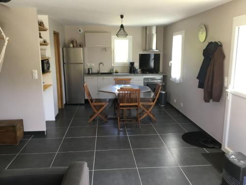 une cuisine et une salle à manger avec une table et des chaises dans l'établissement Maison cosy à Kervilahouen, 1 km de la mer, jardin, terrasse, BBQ, proche supérette, 5 pers. - FR-1-418-192, à Bangor
