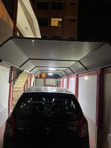 a car parked in a garage with a carport at Alojamiento El Hogar Casa completa - Prado - Centro Cbba in Cochabamba