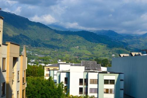 a group of buildings with mountains in the background at Apartamento con vista y ubicación privilegiada in Armenia
