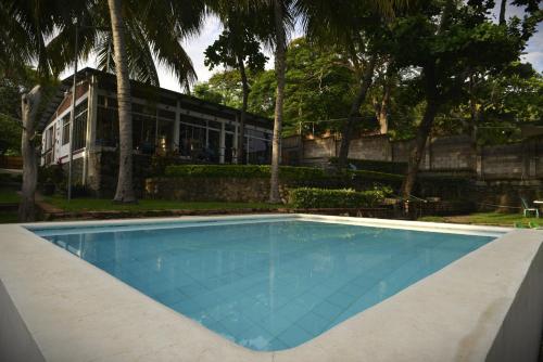 a swimming pool in front of a building at RocaSol Casa d´Mar in El Zonte
