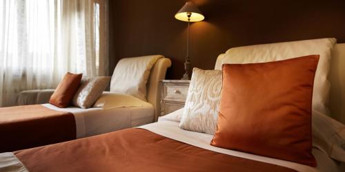 a bedroom with a bed and a couch and a chair at La Dimora Del Bassotto in San Giuliano Terme