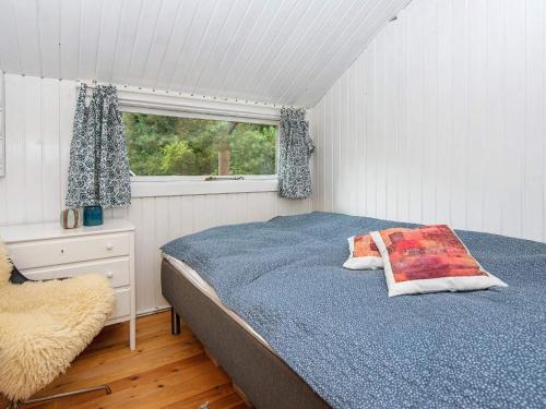 um quarto com uma cama e uma janela em Holiday home Knebel LII em Knebel