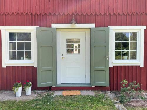 a red house with a green door and two windows at 4 person holiday home in Ljungbyhed-By Traum in Ljungbyhed
