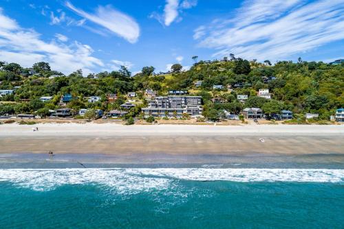 a view of a beach with houses on a hill at The Sands Apartment 23 - Stay Waiheke in Onetangi