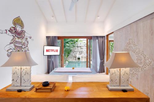 a bedroom with two lamps on a table and a bed at The Jimbaran Villa by Ini Vie Hospitality in Jimbaran