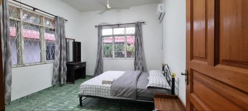 a bedroom with a bed and a window at Kenyalang Lutong Homestay in Miri