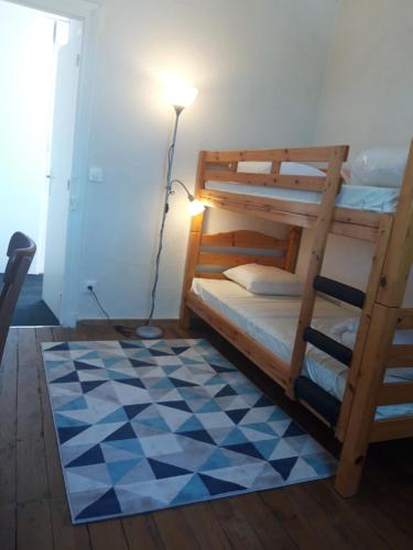 1 dormitorio con literas, lámpara y suelo a cuadros en Maison individuelle draps et serviettes non inclus, en Morcenx