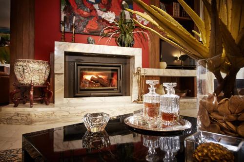 a living room with a fireplace and a table with glasses at La Dimora Del Bassotto in San Giuliano Terme
