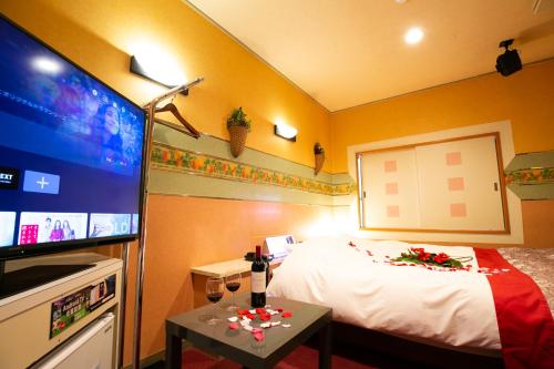 a hotel room with a bed and a flat screen tv at Restay lagoon in Tokyo