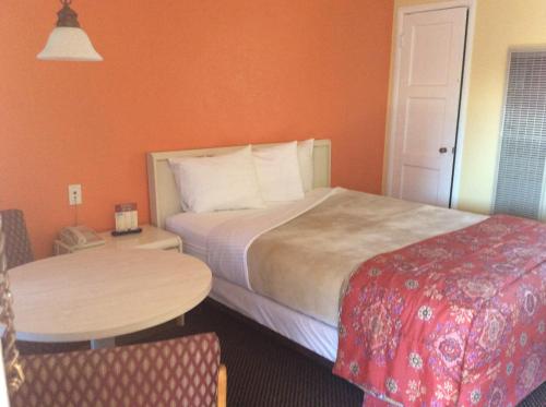 a hotel room with a bed and a table at Los Padres Inn in San Luis Obispo