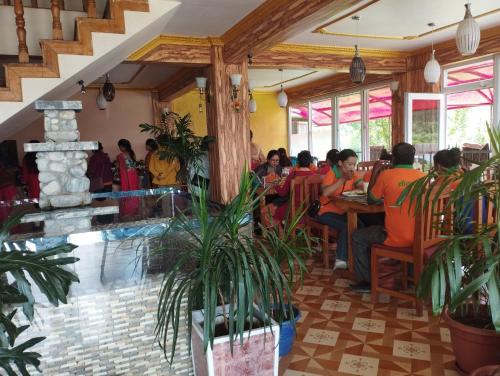 un grupo de personas sentadas en una mesa en un restaurante en Paradise Villa en Nagarkot