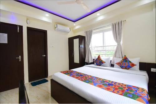a bedroom with a large bed and a window at FabHotel Anchorage Inn - Nr Axis Mall in Kolkata