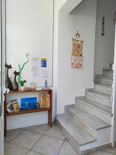 a staircase in a room with a shelf and a wall at Sofia Studios & Apartments in Georgioupolis