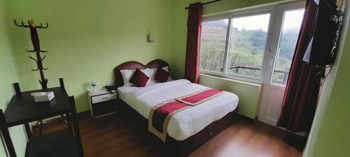 a bedroom with a bed and a large window at Paradise Villa in Nagarkot