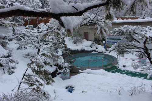 a snow covered yard with a swimming pool at The K Hotel Gyeongju in Gyeongju