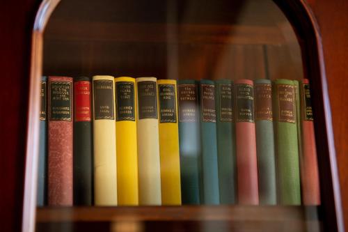 a row of books sitting on a shelf at Anchorage Seafront Hotel in Victor Harbor