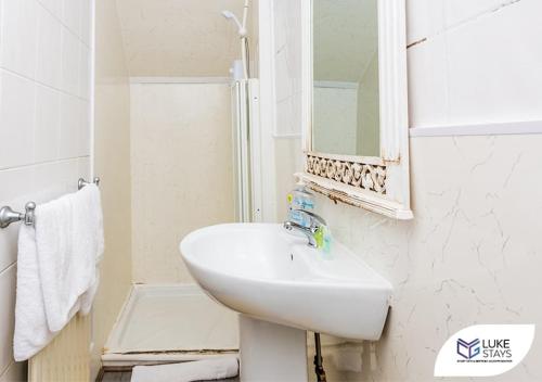 a white bathroom with a sink and a mirror at Luke Stays - Brandling Street in Monkwearmouth