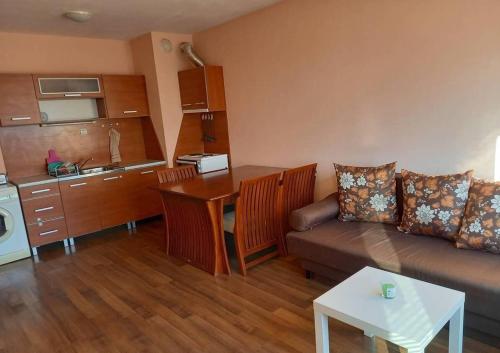 a living room with a couch and a table and a kitchen at Апартамент Романтика in Varna City