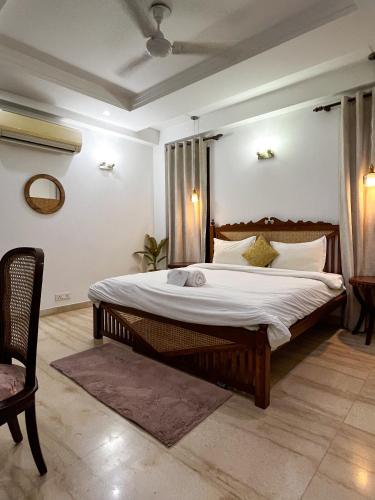 a bedroom with a large bed with white sheets at Avatar Living @Safdarjung Enclave in New Delhi