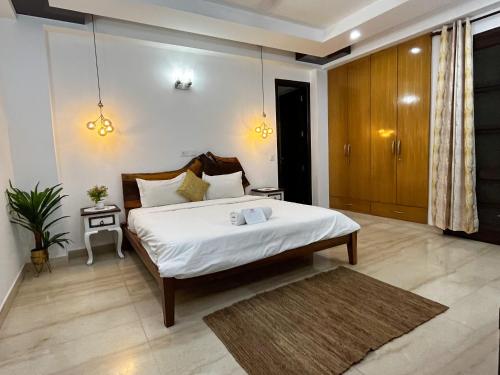 a bedroom with a large bed with white sheets at Avatar Living @Safdarjung Enclave in New Delhi
