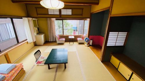 sala de estar con mesa y sofá en ゲストハウス　華屋 (guest house HANAYA）, en Sado