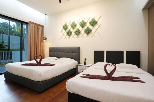 a bedroom with two beds with brown towels on them at AJ Suites @ Loft Imago KK in Kota Kinabalu