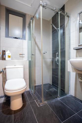 a bathroom with a toilet and a glass shower at AJ Suites @ Loft Imago KK in Kota Kinabalu