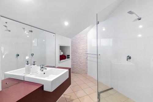 a white bathroom with a sink and a shower at Merlot Verdelho Townhouses in Penola