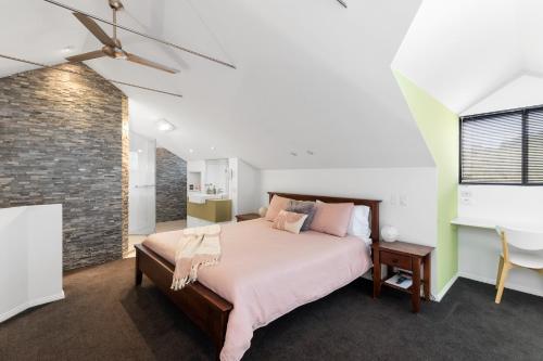 a bedroom with a bed and a brick wall at Merlot Verdelho Townhouses in Penola