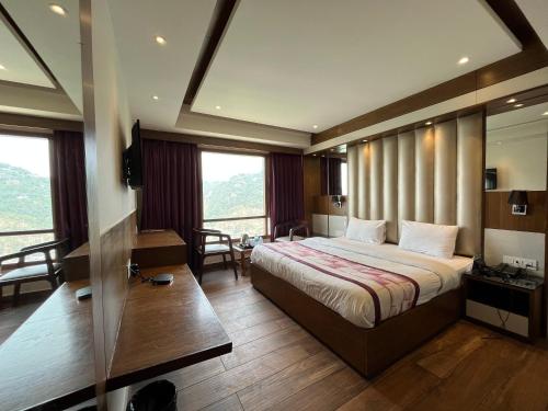 a hotel room with a bed and a large window at Mahaveer Shimla By Royal Collection Hotels in Shimla