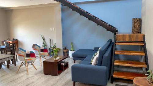 a living room with a blue couch and a staircase at Suites Hermosas cercanas a todo in Puerto Ayora