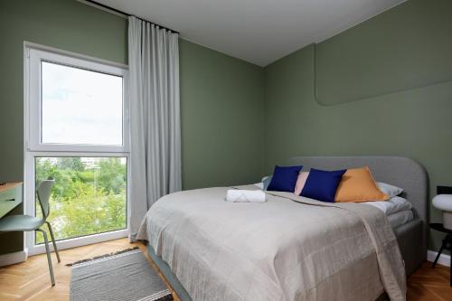 - une chambre avec un lit et une grande fenêtre dans l'établissement Warszawa Bohema Szwedzka Apartment by Renters, à Varsovie