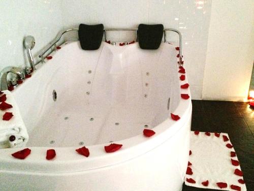 a white bath tub with red hearts on it at Hotel Boutique Embajada de la Feria in Bogotá