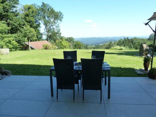 a dining table and chairs with a view of a field at Ferienwohnung Urlaub mit Aussicht in Zenting