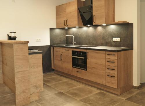 a kitchen with wooden cabinets and a sink at Haus Sonnengruß in Salem