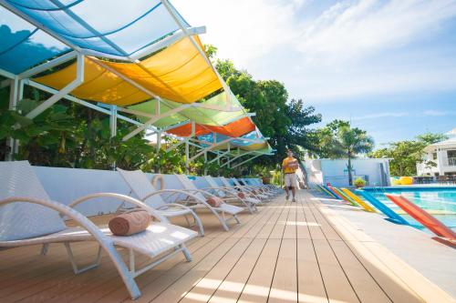 a row of chairs next to a swimming pool at Maayo San Remigio in San Remigio