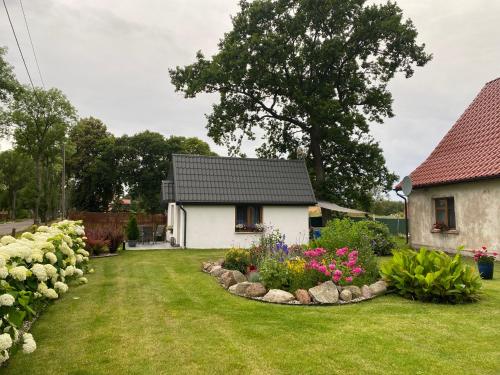 a house with a garden with flowers in the yard at Eko Dolina Kluki in Kluki
