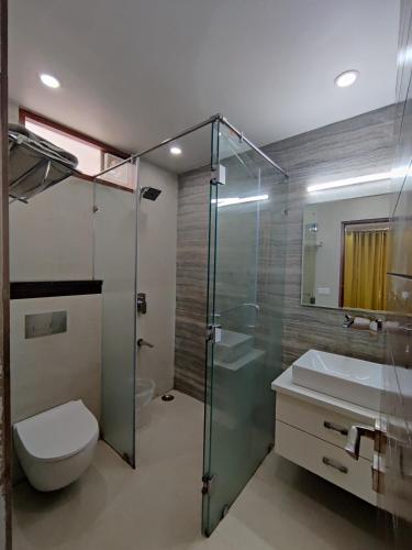 a bathroom with a shower and a toilet and a sink at MOON3BHK By Wabi Sabi Stays in Mussoorie