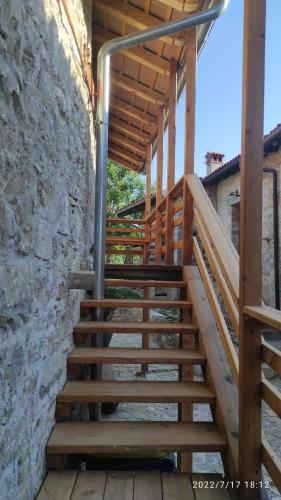 a wooden staircase in a building with a stone wall at Holiday Farmhouse Skvor in Robidišče
