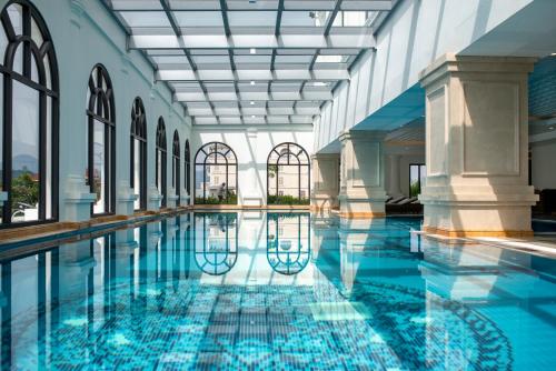 a swimming pool with blue water in a building at Melia Vinpearl Tay Ninh in Tây Ninh