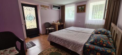 een slaapkamer met een bed, een raam en een deur bij Guest House Panda in Koetaisi