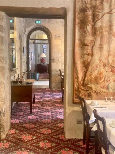 un couloir avec une table et un tableau sur le mur dans l'établissement Hôtel Le France, à Aubusson