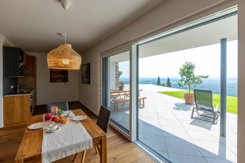 a dining room with a table and a large glass door at Greim15 --- Apartment mit Fernsicht und Pool 50m2 in Greim