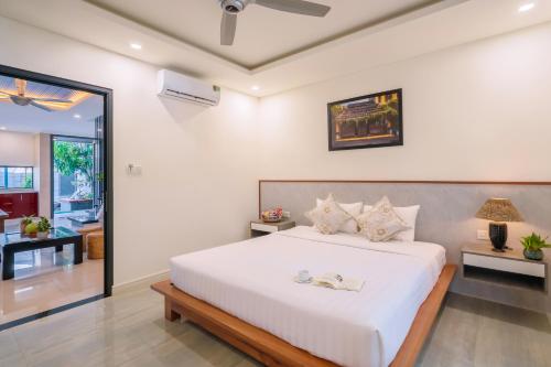 a bedroom with a large white bed in a room at Aroma Garden Suites Hoi An in Hoi An