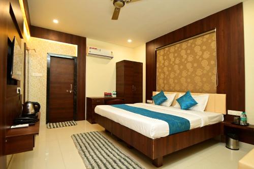 ein Schlafzimmer mit einem großen Bett mit blauen Kissen in der Unterkunft Hotel Hallmark By THC Group in Kota