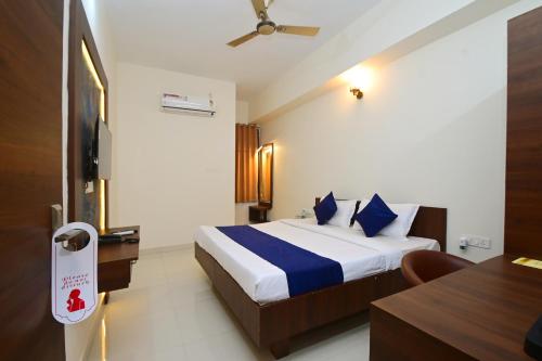 a hotel room with a bed with blue pillows at Hotel Hallmark By THC Group in Kota