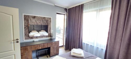 a bedroom with a large mirror above a fireplace at Valencia Gardens Apartment & Studio, Nesebar in Nesebar