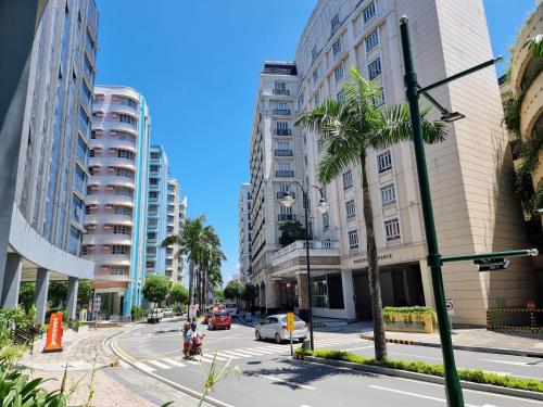 a city street with tall buildings and a palm tree at Condo Airport NAIA Terminal-3 One Palm Tree Villas in Manila