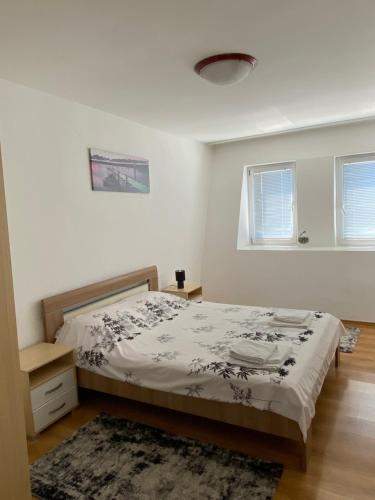 Habitación blanca con cama y alfombra en Apartman - stan na dan LENJINKA, en Vranje